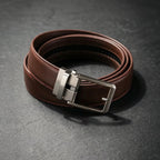 Brown leather belt with a silver buckle on a dark gray background