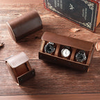 Brown leather watch box with three watches on a wooden surface, featuring the brand 'QINBAN'.